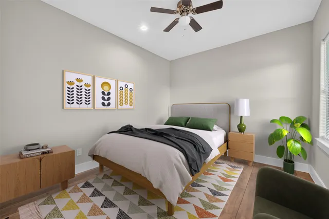 a bedroom with a bed lamp and a potted plant