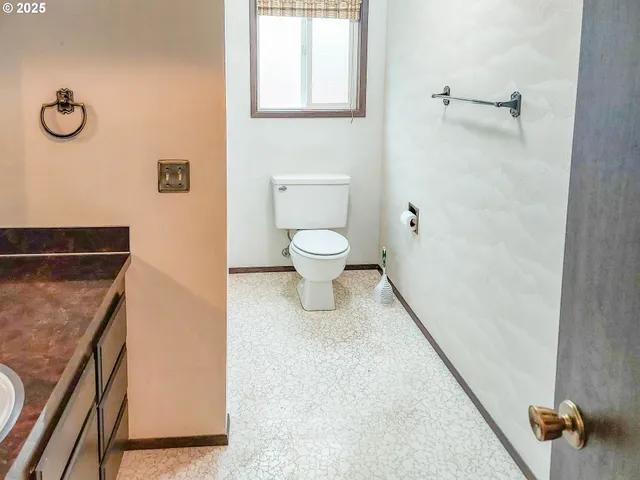 a bathroom with a granite countertop toilet and a shower