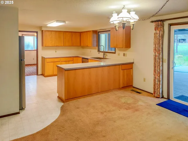 a kitchen with stainless steel appliances granite countertop a sink a stove and a refrigerator