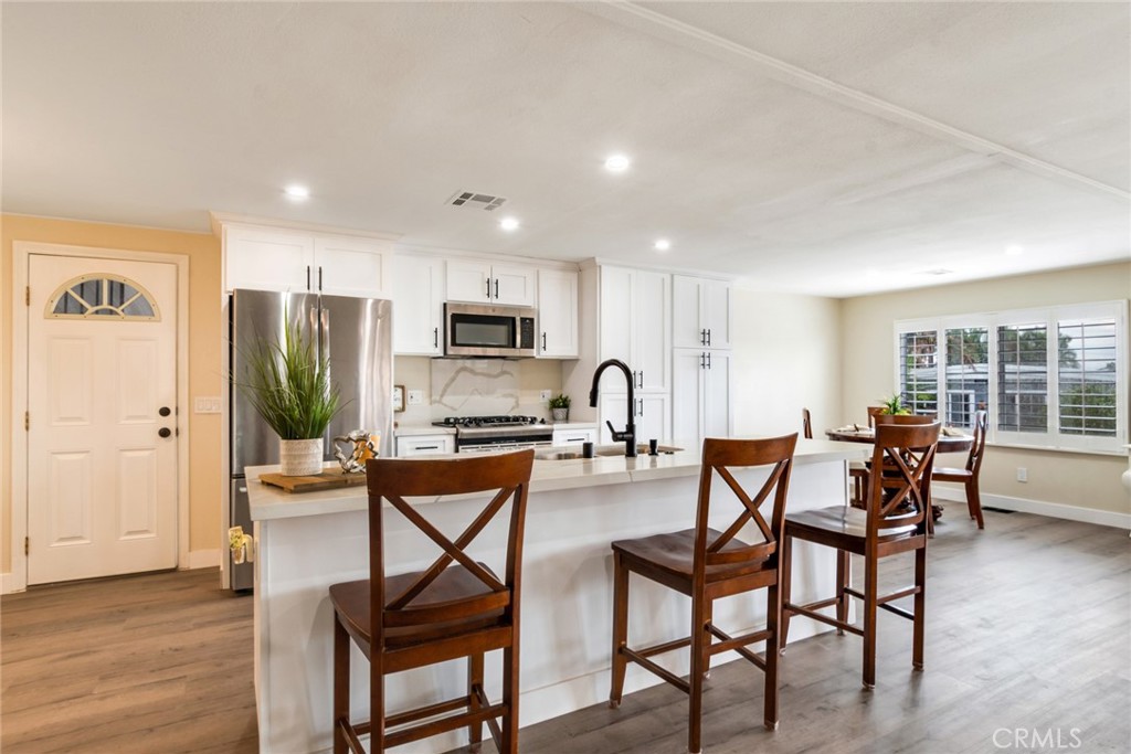 10210 Base Line Road, Unit 115 Rancho Cucamonga, CA 91701 - Photo 3 of 23 a view of a dining room with furniture and wooden floor