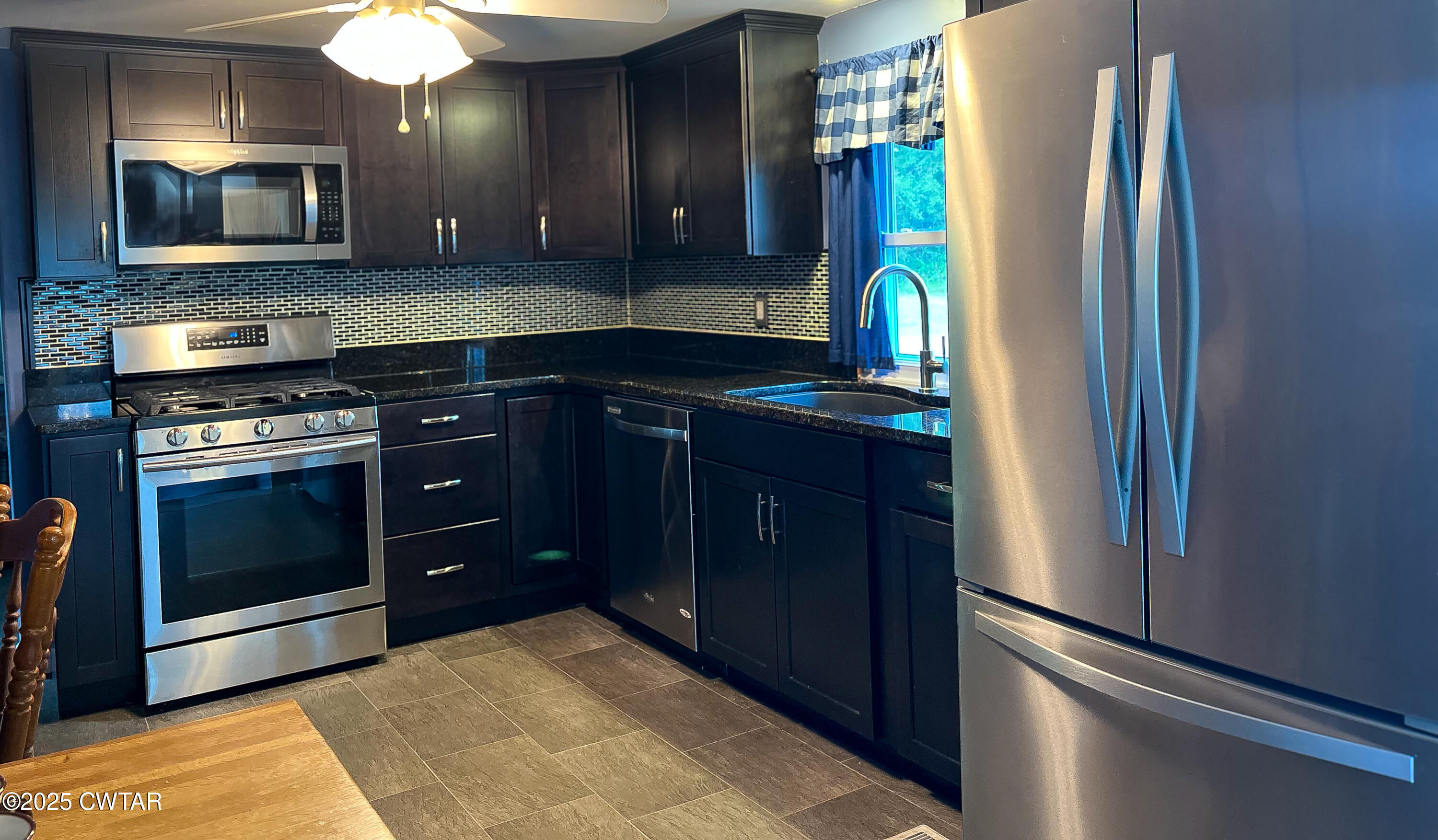 154 North Winchester Street McKenzie, TN 38201 - Photo 13 of 24 a kitchen with stainless steel appliances granite countertop a refrigerator and a sink