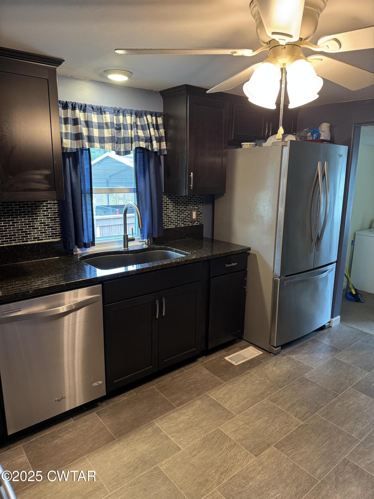 154 North Winchester Street McKenzie, TN 38201 - Photo 14 of 24 a kitchen with stainless steel appliances granite countertop a refrigerator and a sink