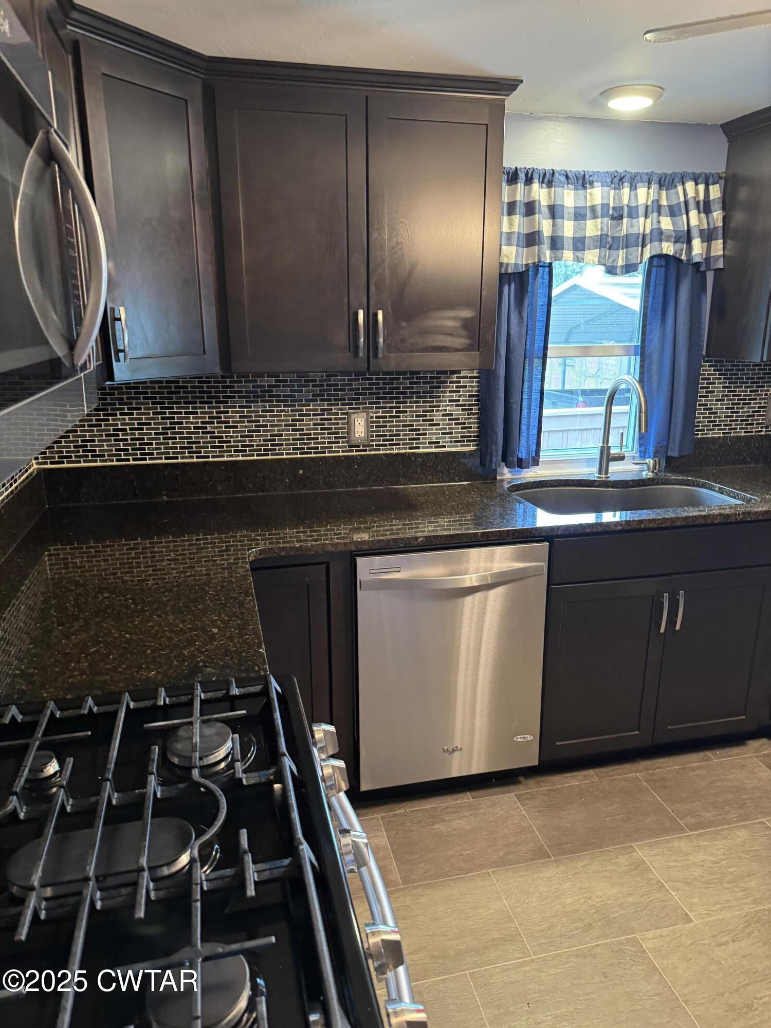 154 North Winchester Street McKenzie, TN 38201 - Photo 15 of 24 a kitchen with stainless steel appliances granite countertop a stove a sink and a microwave