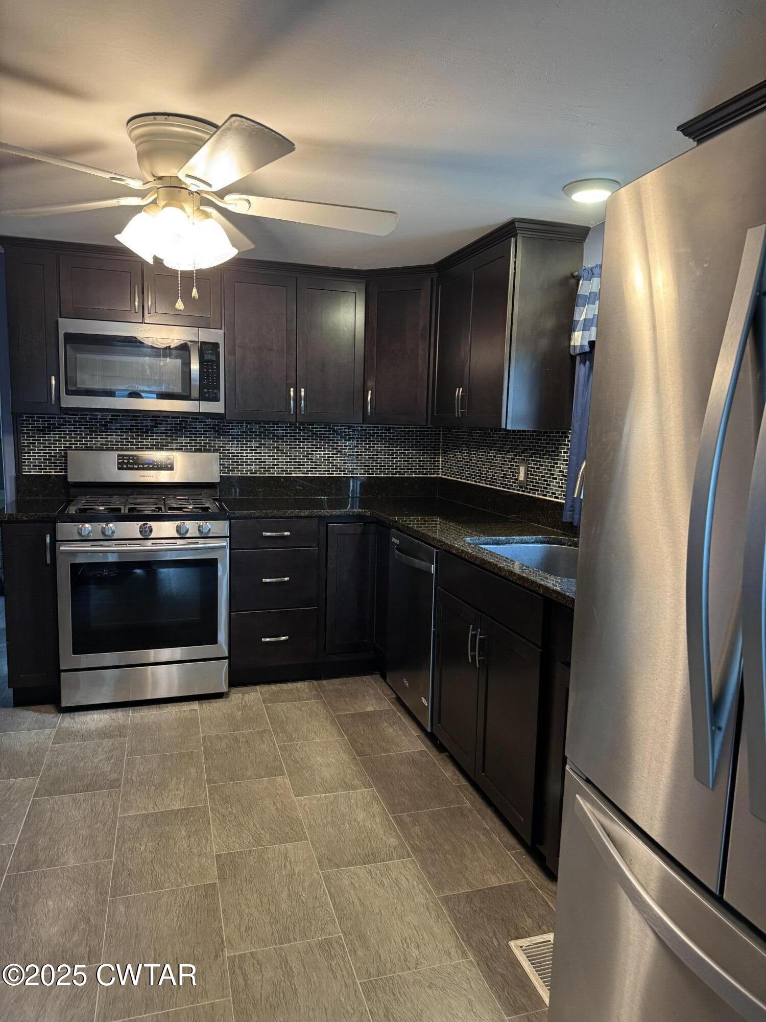 154 North Winchester Street McKenzie, TN 38201 - Photo 16 of 24 a kitchen with stainless steel appliances granite countertop a stove a refrigerator and a sink