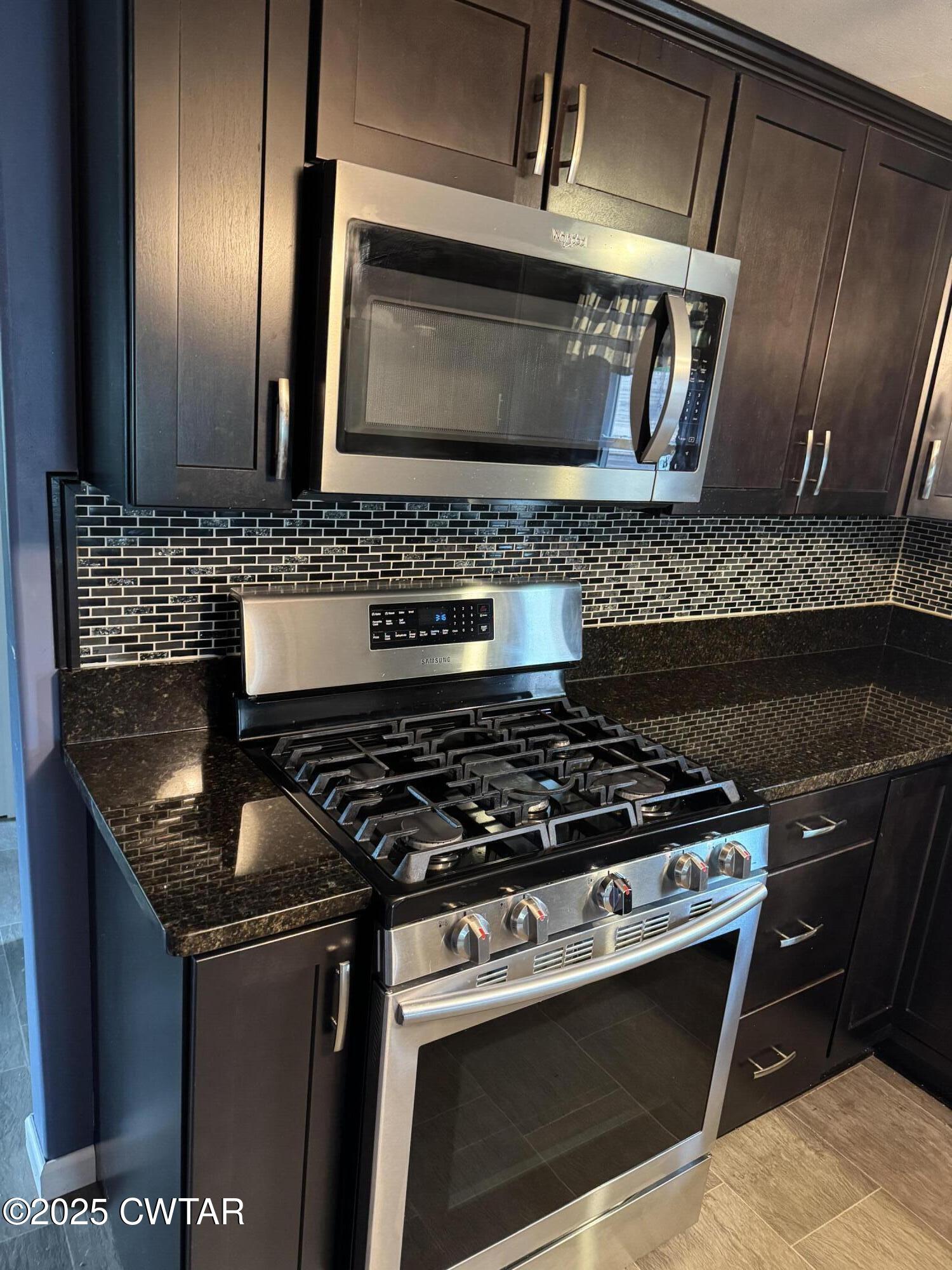154 North Winchester Street McKenzie, TN 38201 - Photo 18 of 24 a kitchen with granite countertop stainless steel appliances and wooden cabinets