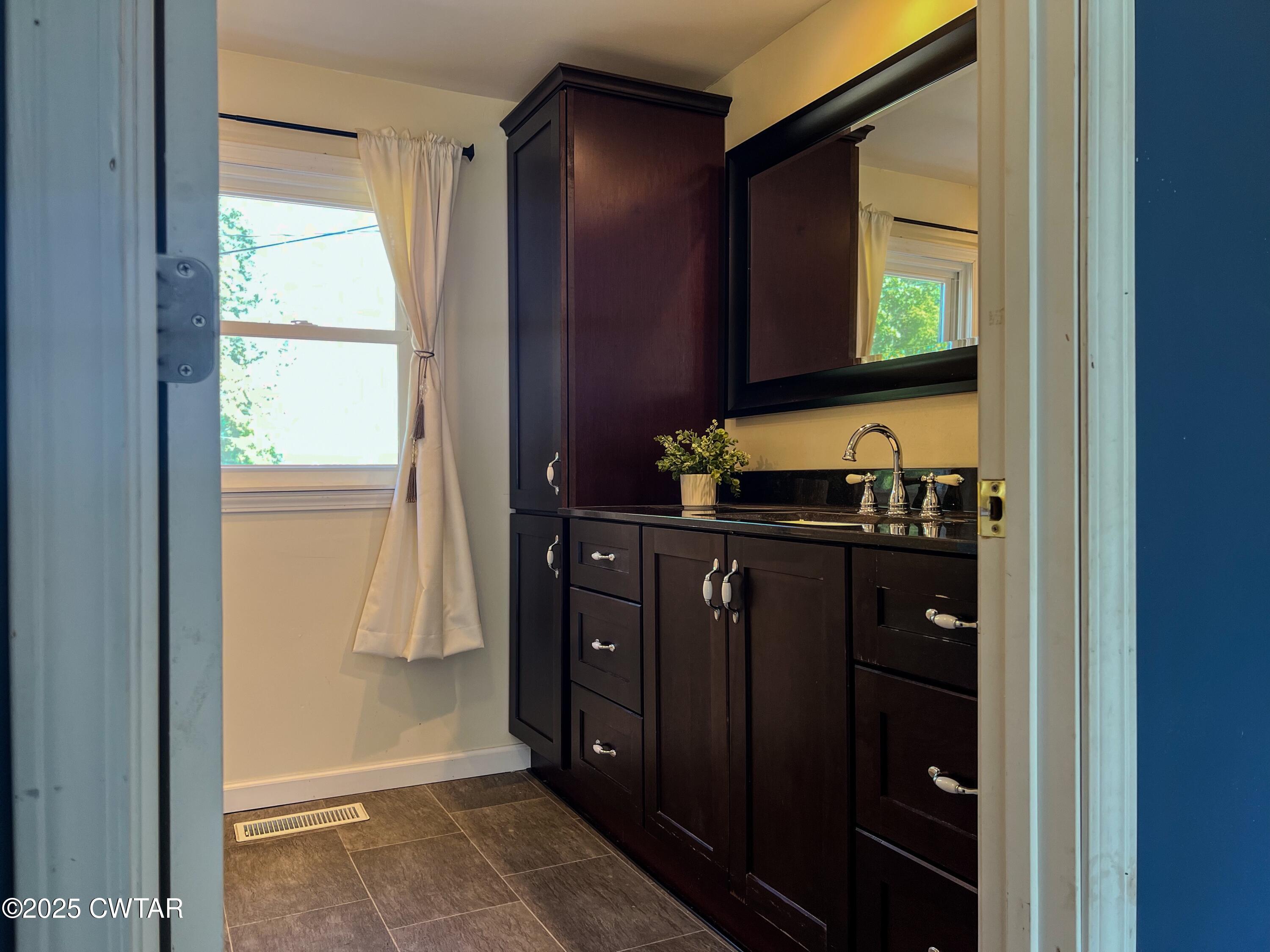 154 North Winchester Street McKenzie, TN 38201 - Photo 10 of 24 a bathroom with a double vanity sink and a mirror