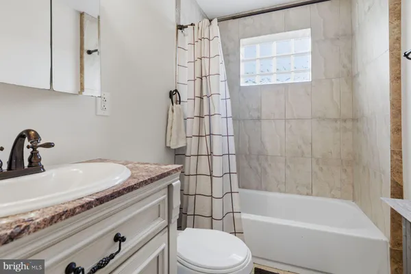 a bathroom with a sink a toilet and bathtub