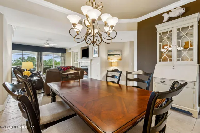 a view of a dining room with furniture a chandelier and wooden floor