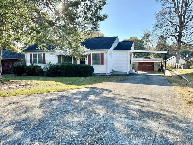 a front view of a house with a yard and trees