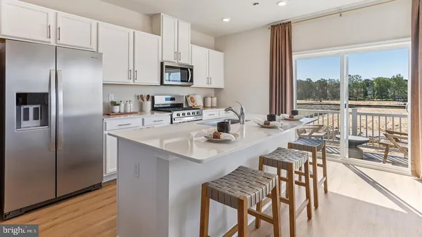 a kitchen with kitchen island a large window appliances and cabinets