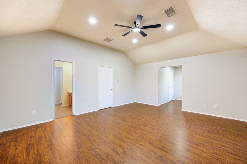 11010 Crosby Field Lane Houston, TX 77034 - Photo 11 of 15 a view of an empty room with wooden floor and a ceiling fan