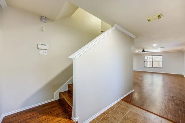 a view of a hallway with wooden floor and staircase