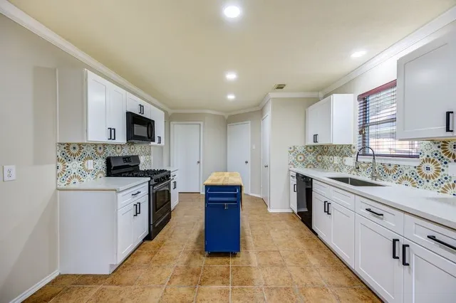 a kitchen with stainless steel appliances granite countertop a stove top oven a sink dishwasher and a refrigerator with wooden floor