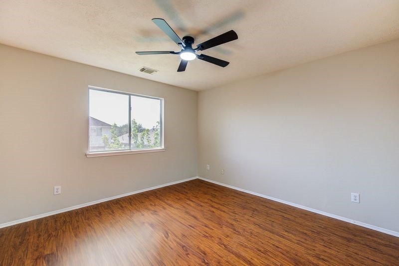 11010 Crosby Field Lane Houston, TX 77034 - Photo 7 of 15 an empty room with wooden floor ceiling fan and windows