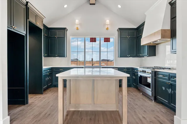 a kitchen with stainless steel appliances granite countertop a stove a sink and a refrigerator