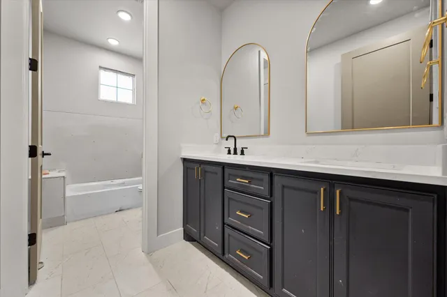 a bathroom with a tub sink and mirror