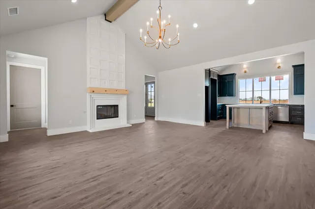 a view of a kitchen with a sink stove cabinets and empty room