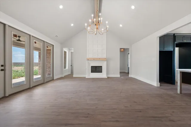 a view of an empty room with a fireplace and a window