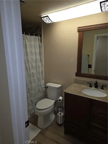 a bathroom with a granite countertop toilet sink and mirror