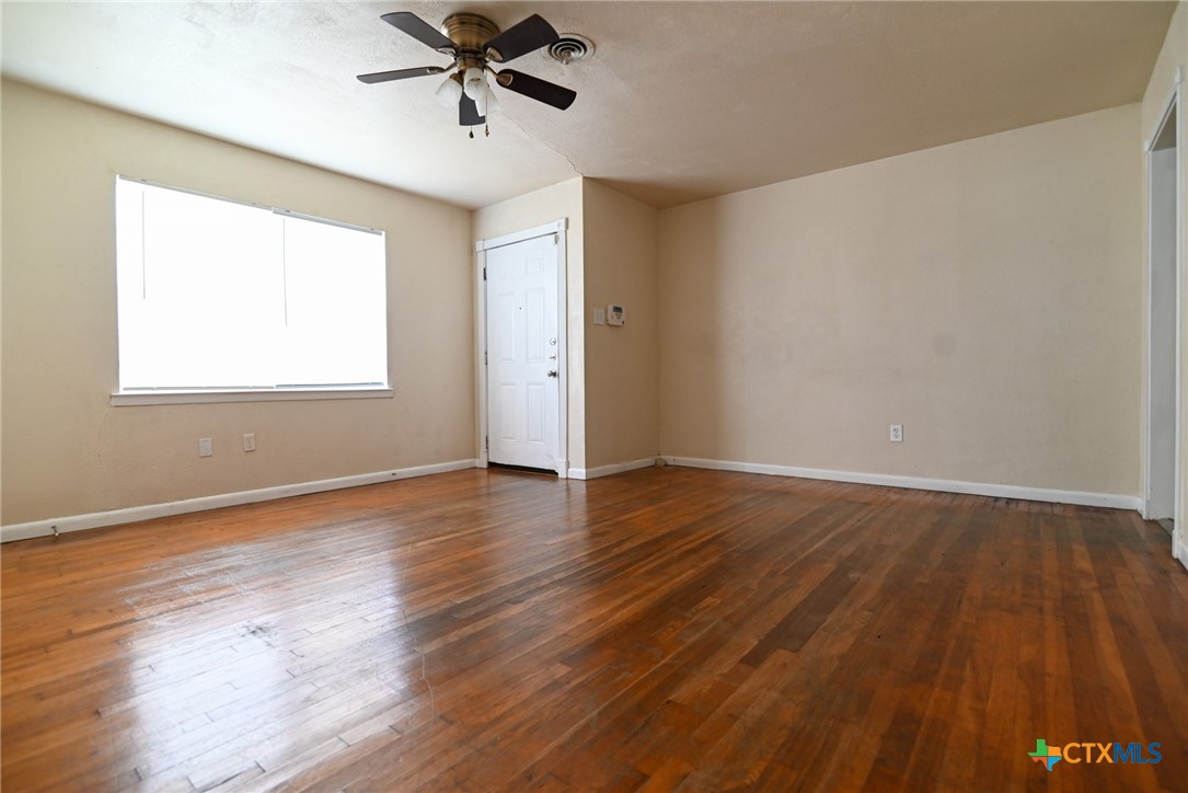 707 South 5th Street Copperas Cove, TX 76522 - Photo 5 of 19 an empty room with wooden floor and windows