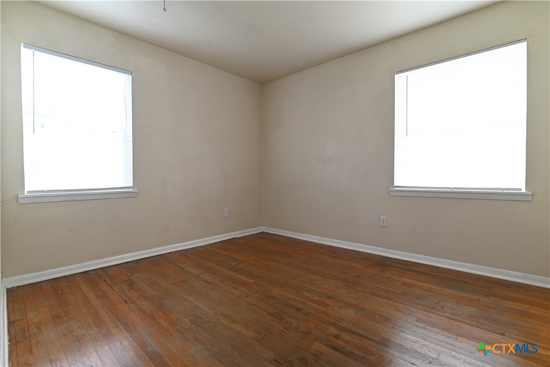 707 South 5th Street Copperas Cove, TX 76522 - Photo 8 of 19 an empty room with wooden floor and a window