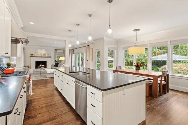 a kitchen with stainless steel appliances granite countertop a sink a stove and a wooden floors