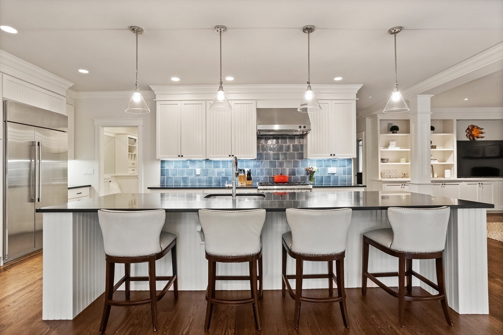 244 Musterfield Road Concord, MA 01742 - Photo 13 of 41 a kitchen with stainless steel appliances granite countertop a dining table chairs and white cabinets