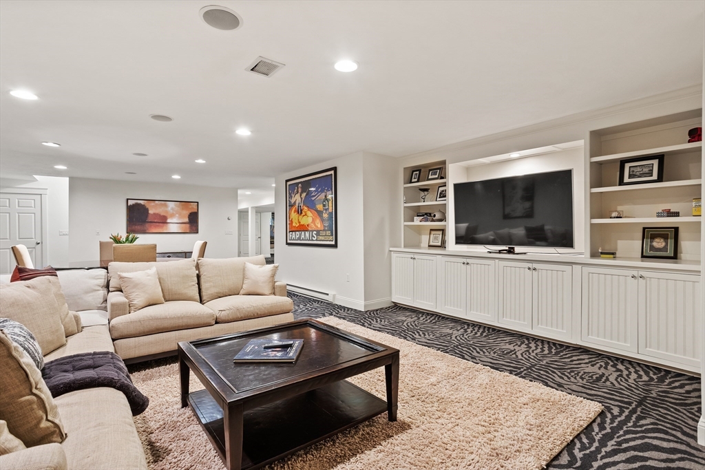 244 Musterfield Road Concord, MA 01742 - Photo 32 of 41 a living room with furniture and a flat screen tv