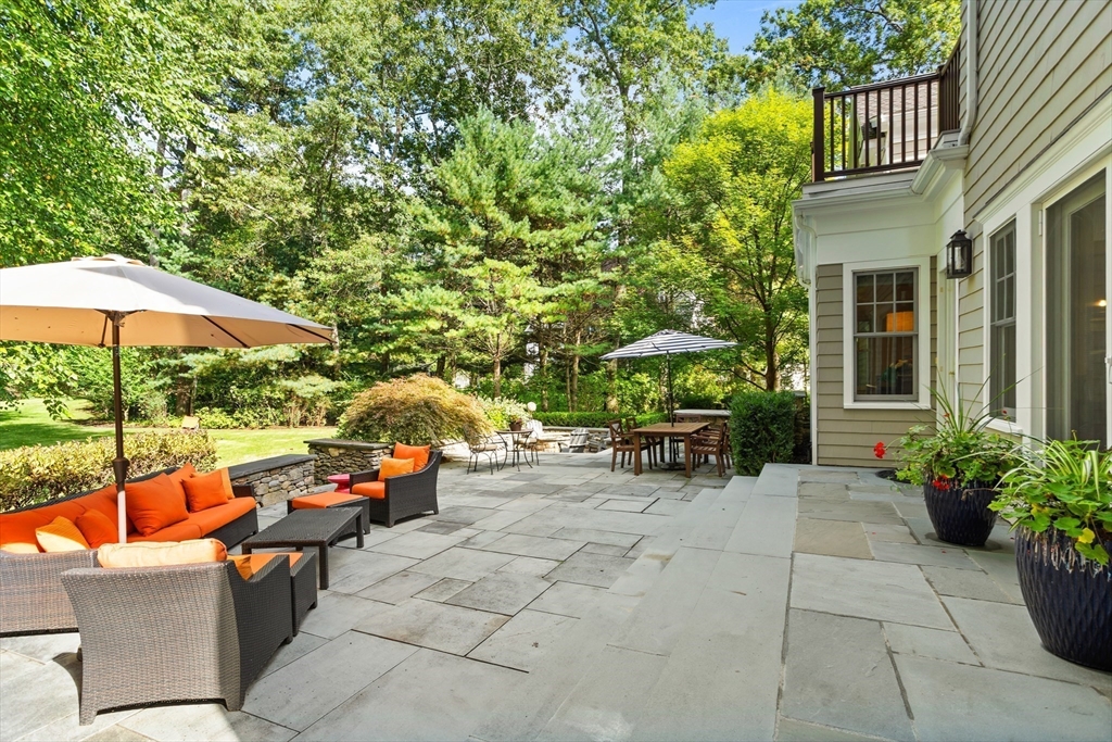 244 Musterfield Road Concord, MA 01742 - Photo 37 of 41 a view of a patio with couches and table and chairs under an umbrella