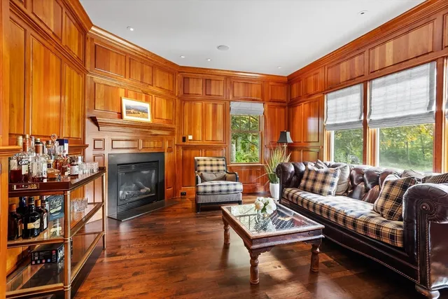 a living room with furniture a fireplace and a floor to ceiling window