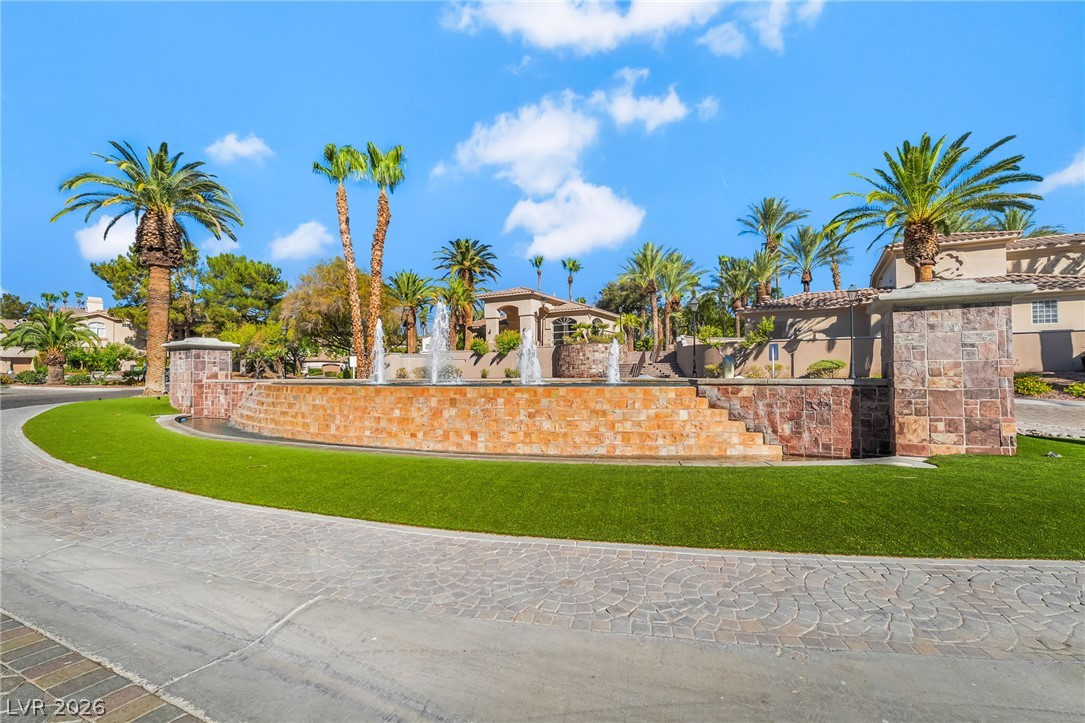 2050 West Warm Springs Road, Unit 2411 Henderson, NV 89014 - Photo 34 of 37 A grand circular driveway leads to a property adorned with lush landscaping and a striking water feature.