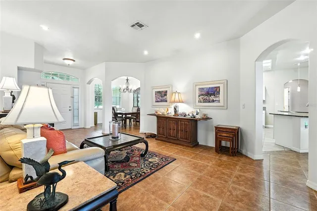 a living room with furniture a rug and kitchen view