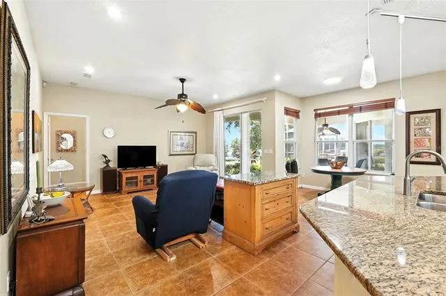 a living room with furniture a flat screen tv and large windows