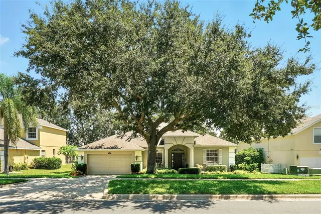 a front view of a house with a garden and trees