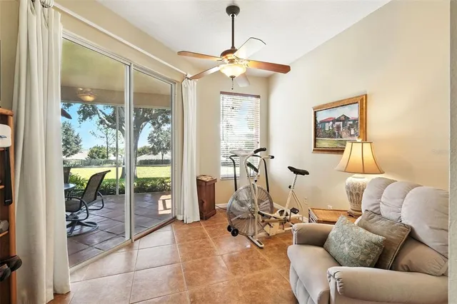a living room with furniture a floor to ceiling window and a flat screen tv