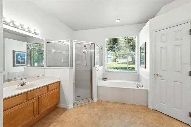 a spacious bathroom with a shower tub double sink and mirror