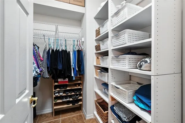 a view of walk in closet with clothes and shoes