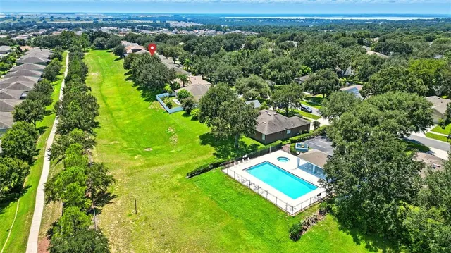 an aerial view of residential houses with outdoor space and trees