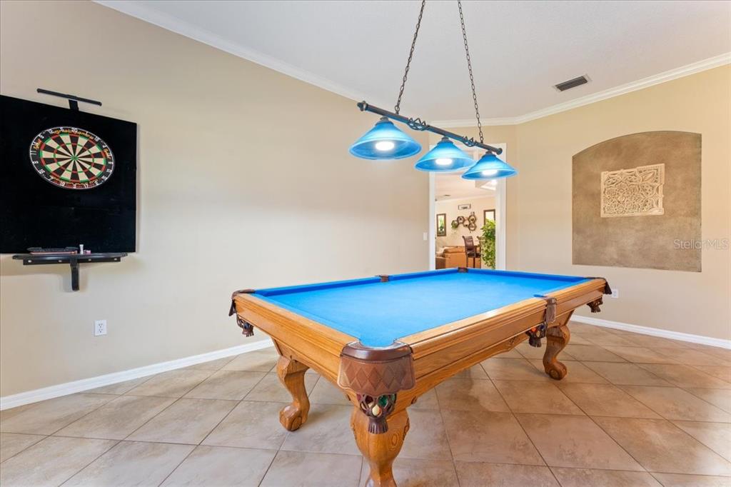 13624 Cooper Road Spring Hill, FL 34609 - Photo 21 of 75 a room with gym equipment and a chandelier