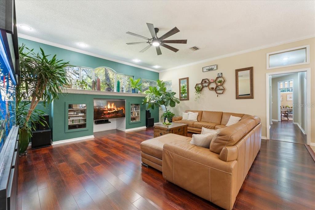 13624 Cooper Road Spring Hill, FL 34609 - Photo 23 of 75 a living room with furniture a fireplace and a flat screen tv