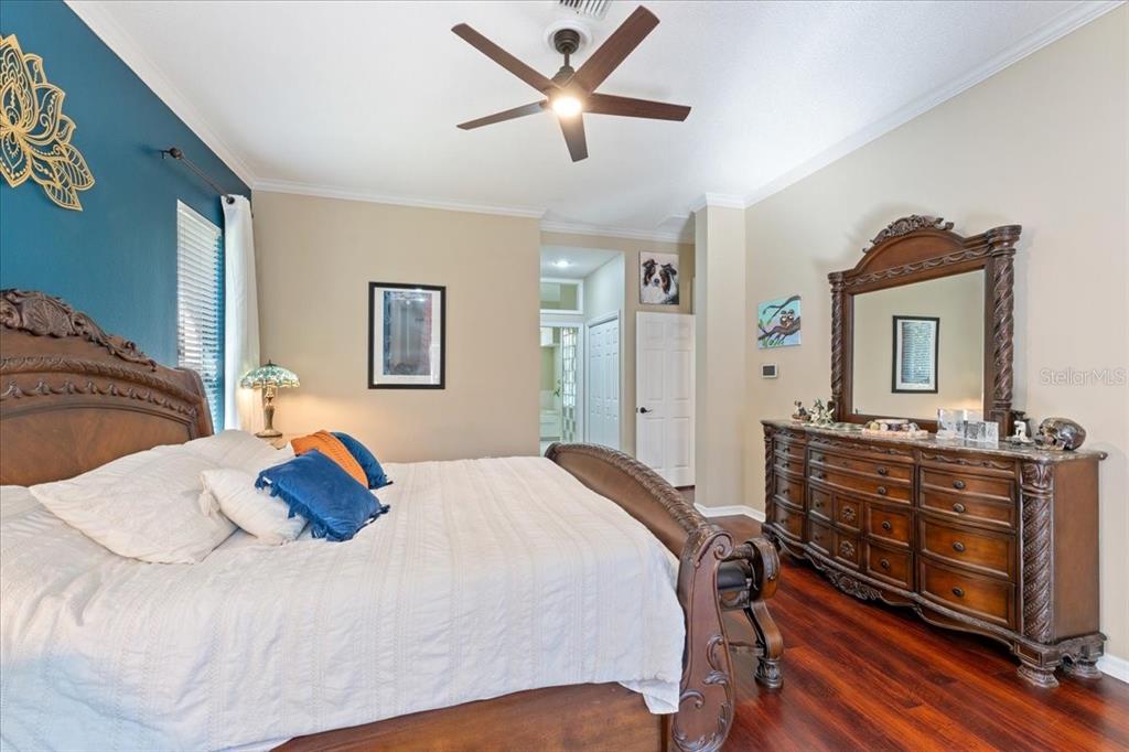 13624 Cooper Road Spring Hill, FL 34609 - Photo 31 of 75 a bedroom with a bed and dresser with mirror