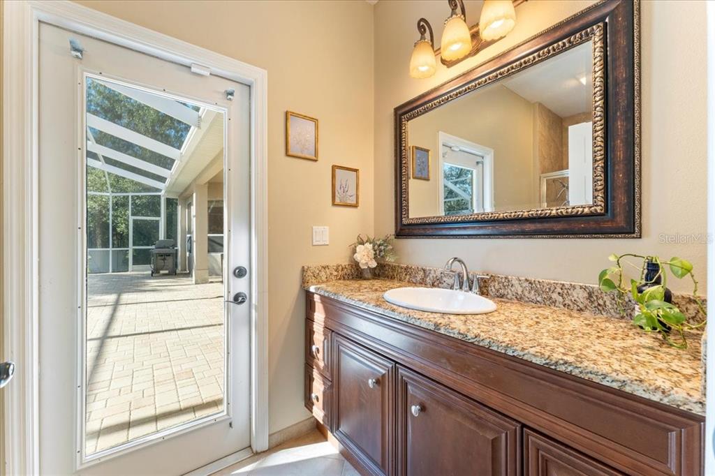 13624 Cooper Road Spring Hill, FL 34609 - Photo 35 of 75 a bathroom with a granite countertop sink vanity and a mirror