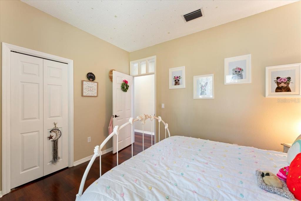 13624 Cooper Road Spring Hill, FL 34609 - Photo 38 of 75 a bedroom with a bed and a wooden floor