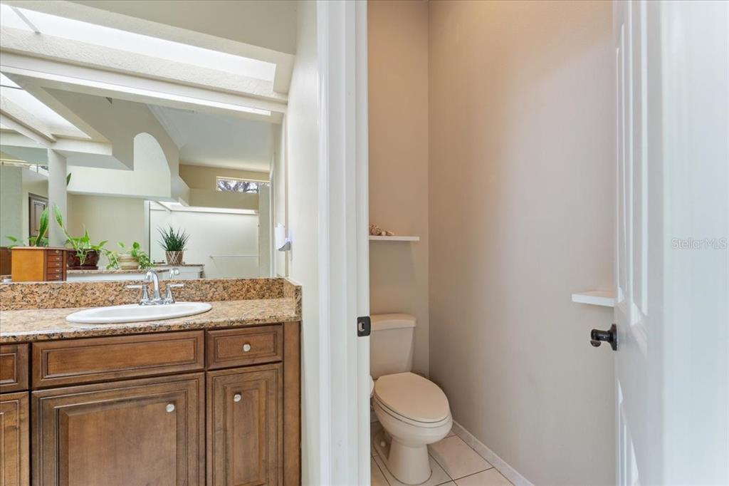 13624 Cooper Road Spring Hill, FL 34609 - Photo 10 of 75 a bathroom with a granite countertop sink mirror vanity and toilet