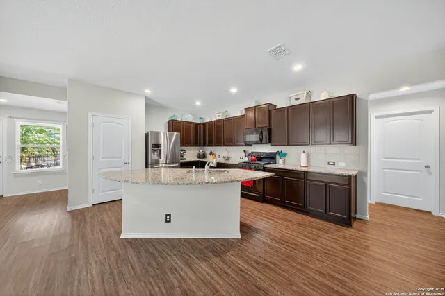 a kitchen with stainless steel appliances granite countertop a sink stove and refrigerator