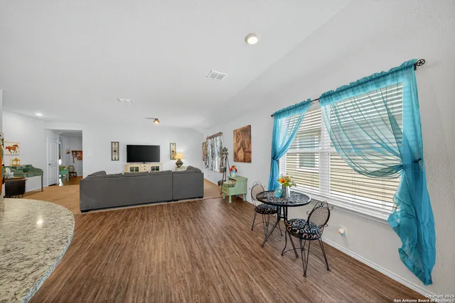 a view of a kitchen with furniture and wooden floor