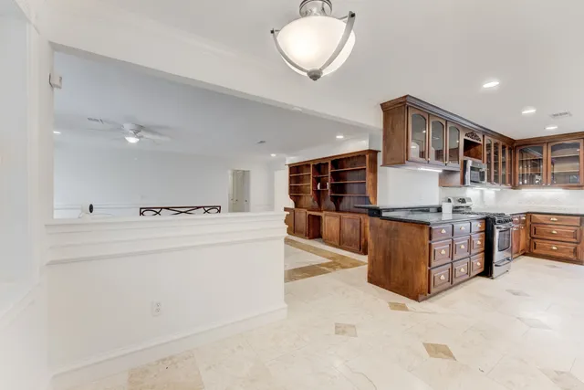 a view of kitchen with kitchen island stainless steel appliances sink stove and cabinets