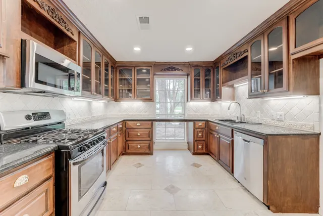a kitchen with stainless steel appliances granite countertop a stove and cabinets