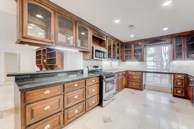 a kitchen with stainless steel appliances granite countertop a stove and cabinets