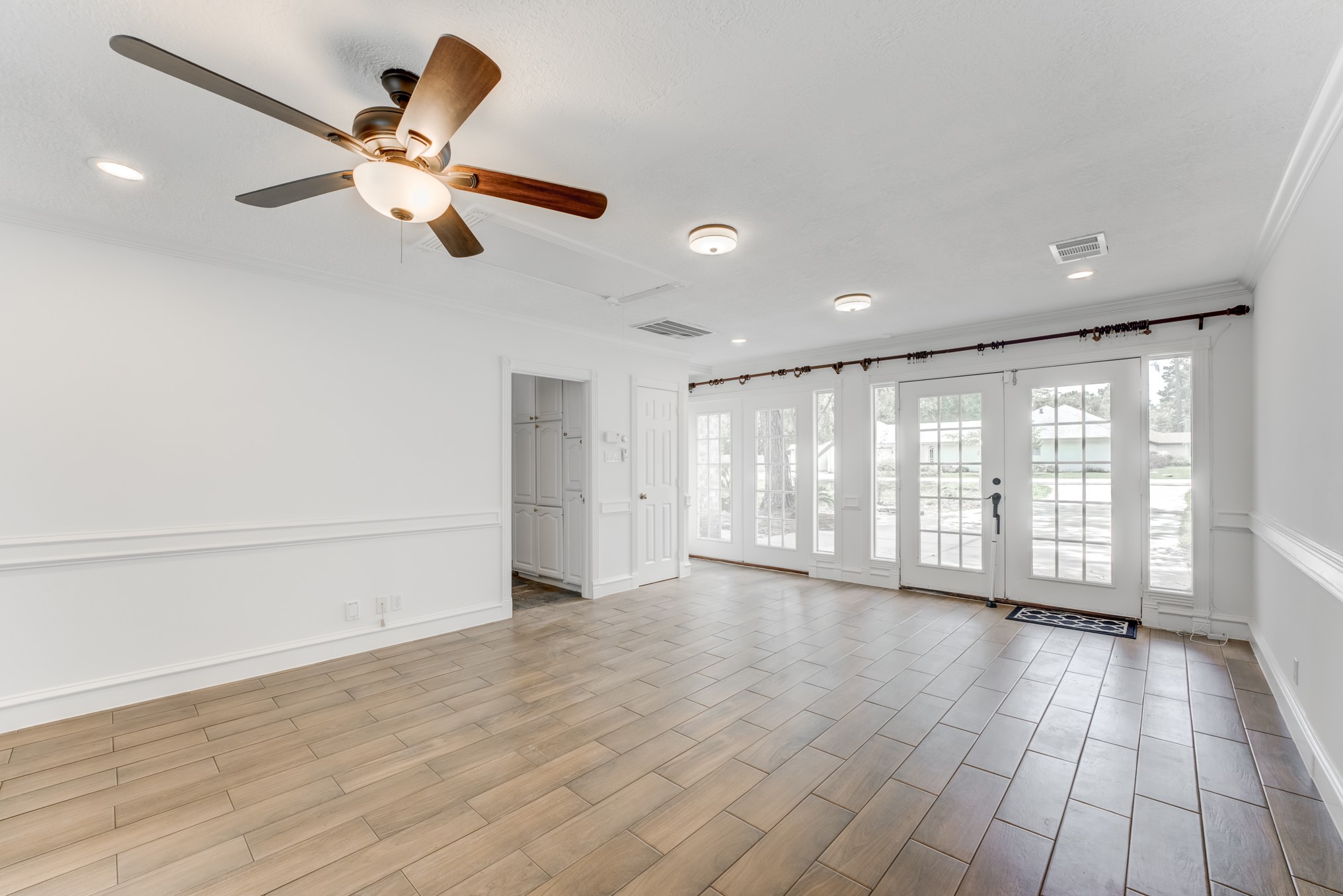 323 Spring Woods Drive Spring, TX 77386 - Photo 45 of 50 an empty room with wooden floor fan and windows